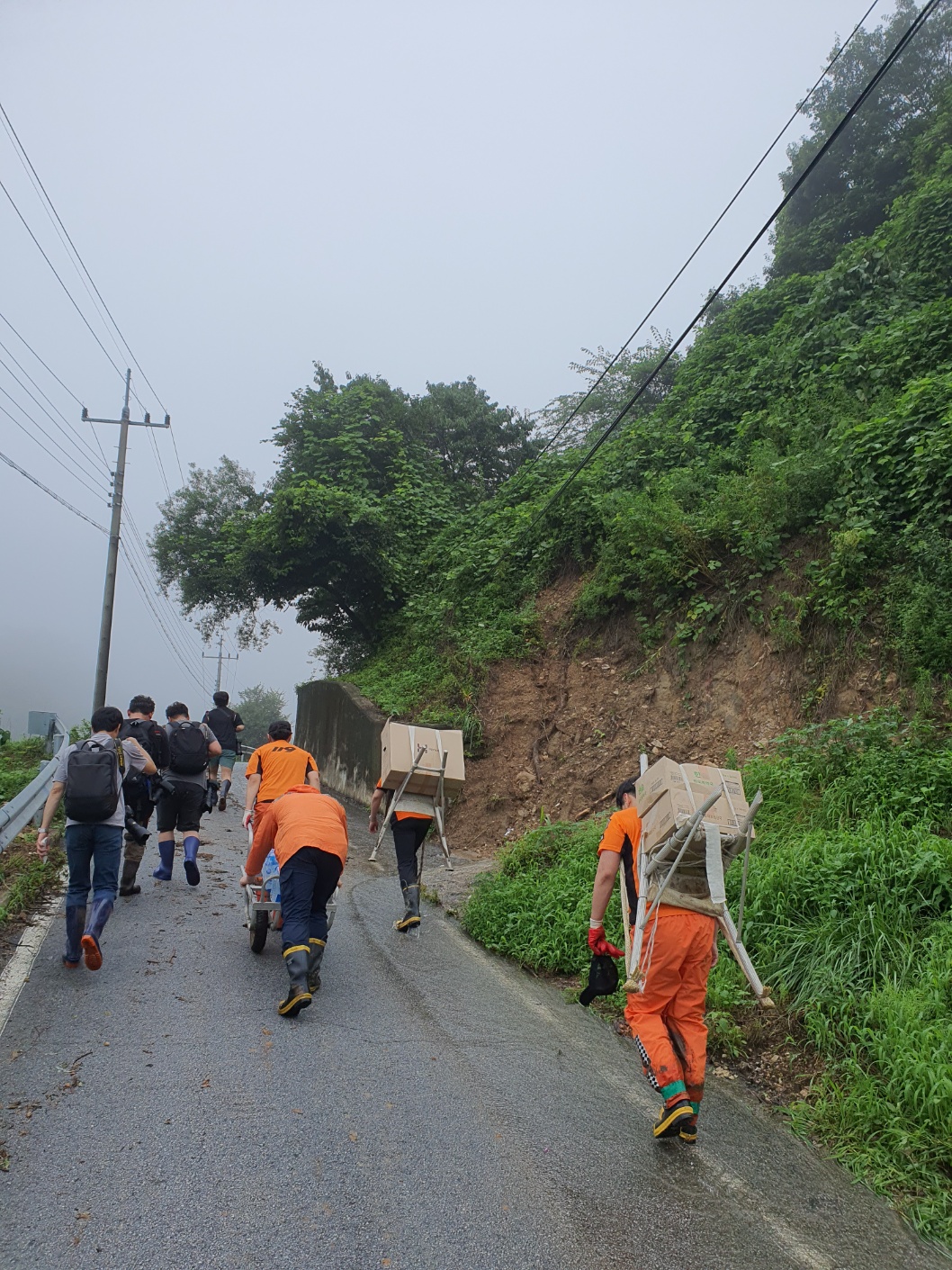 경북소방본부는 폭우로 고립된 마을 주민에거 음식물을 공급하기 위해 기게로 운반하고있다.